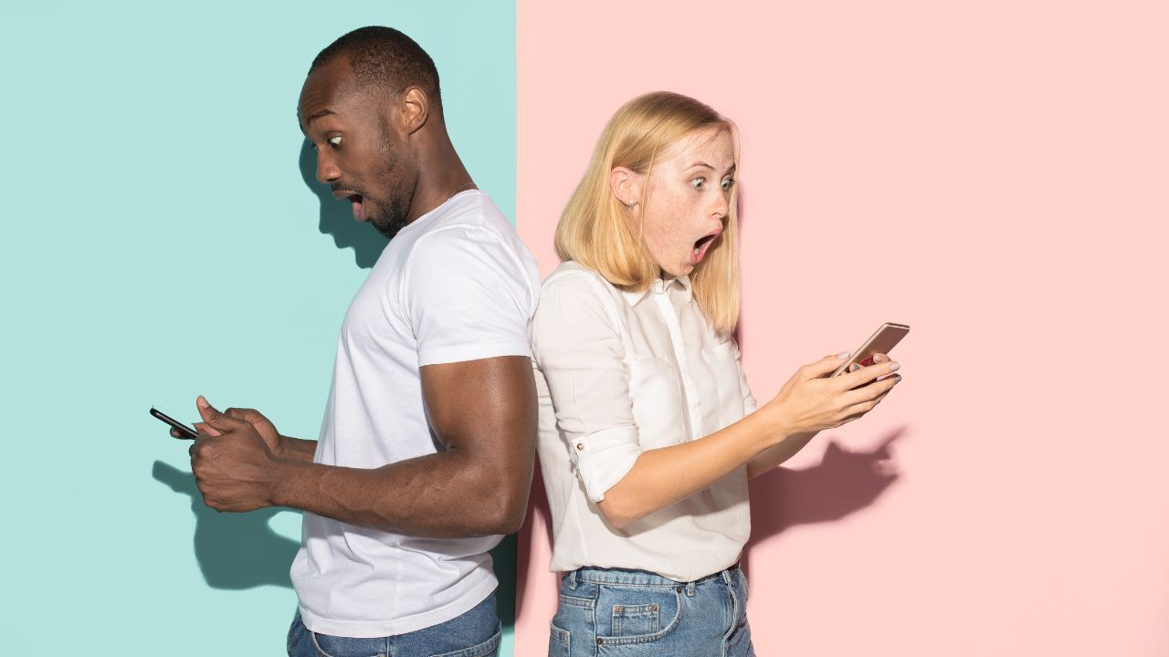 Custom Coach Website vs Template: Better Results for Coaches man and woman back to back each looking at their own phone screen in surprise