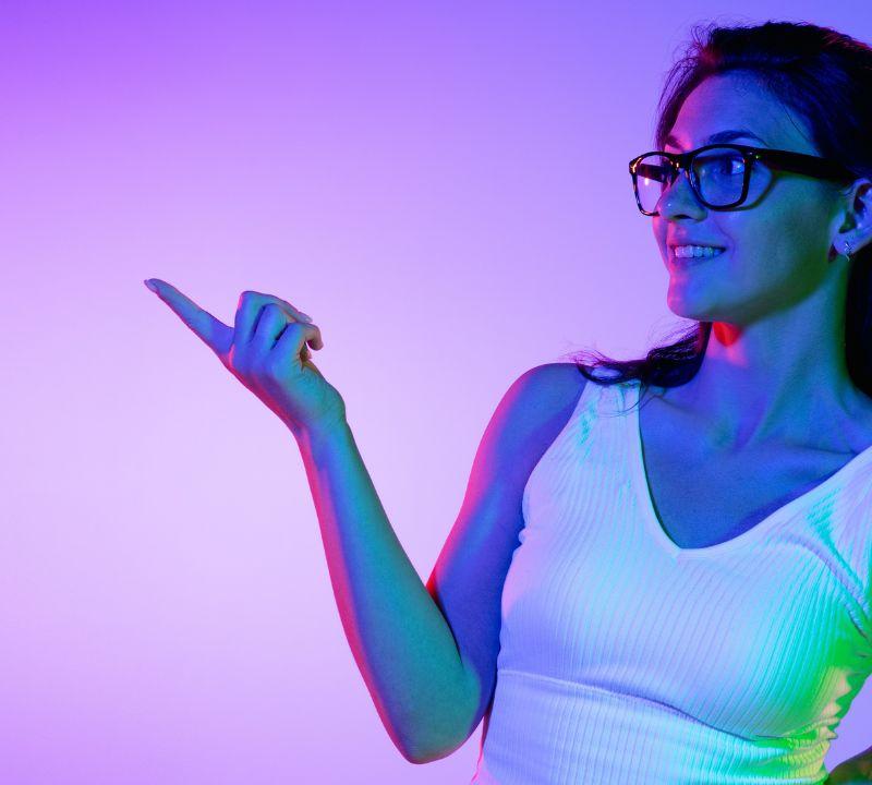 Confident female coach in a white tank top pointing to the side, highlighting the value of hiring a custom website designer Confident female coach in a white tank top pointing to the side, highlighting the value of hiring a custom website designer